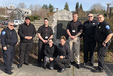 Image of eight members of the Tulalip police smiling in front of a farm