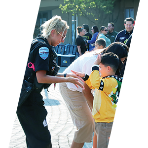 Woman officer with a young boy interacting with the public during an event